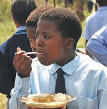 Kind beim Essen bei SOP-Projekt in Nkandla